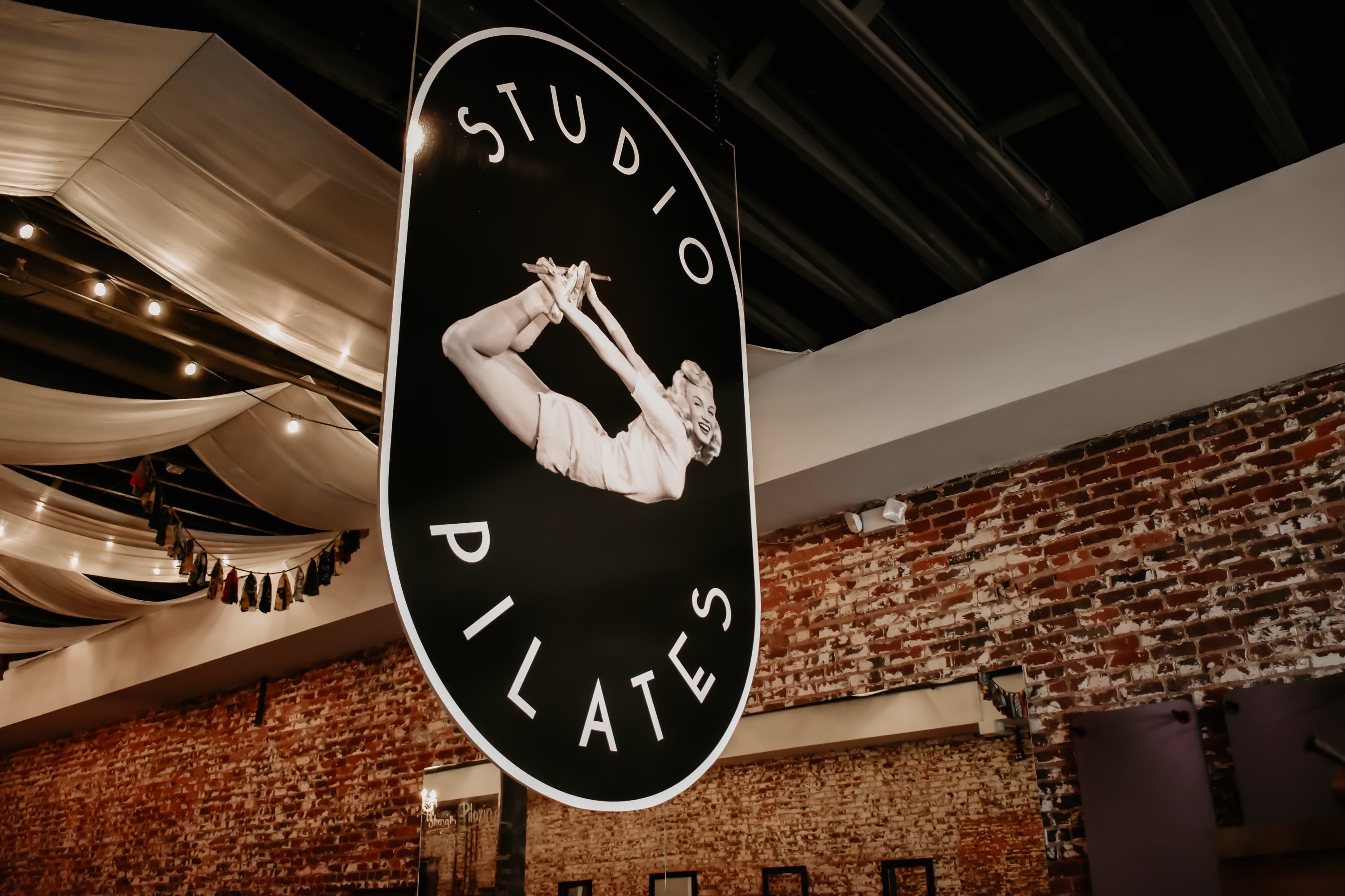 The original Studio Pilates sign, exposed brick, and draped ceilings inside the Columbus studio